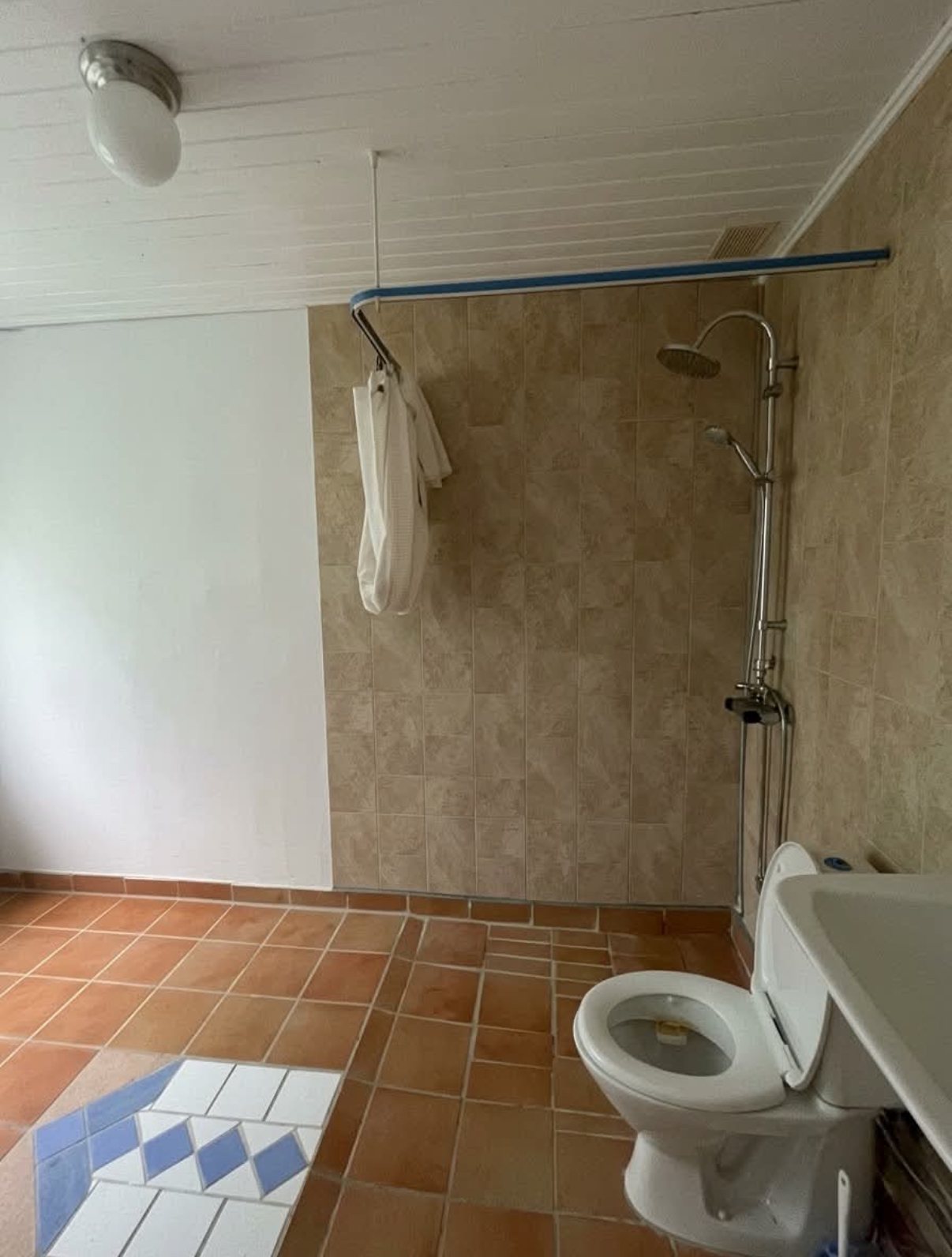 Badeværelse før renovering – gamle klinker og åben bruser